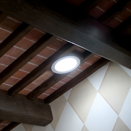 A solar tube in the ceiling among exposed rafters to illustrate Solar Tube Installation Vancouver WA. and Installing a Solar Tube