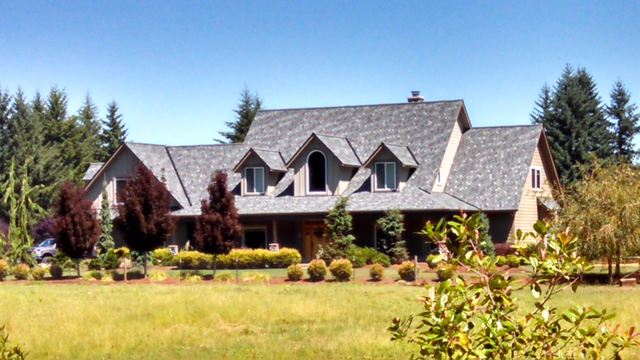 Gray asphalt shingle roofing project on a large home in the country.
