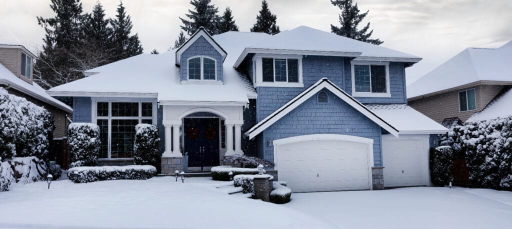 A snow covered home to illustrate Winter roof maintenance tips