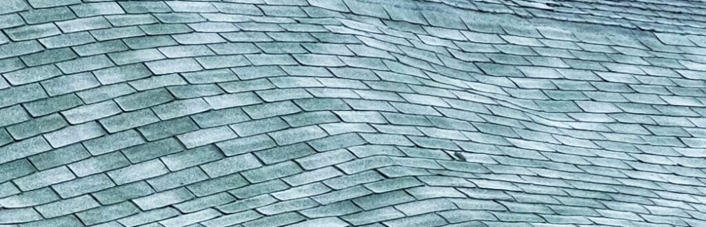 Wavy roof that needs to be replaced to help illustrate how to a roof tear off and roof structure repair.