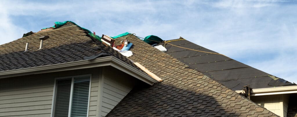 Roof shingles being replace on a home to illustrate how often should you reshingle your roof and roofing and skylight installation.