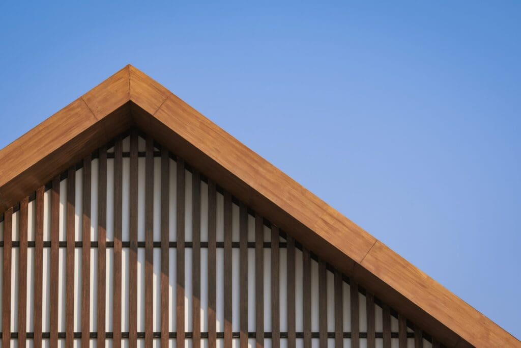 Wooden gable roof with battens decoration of vintage house against blue clear sky background to illustrate Metal Roof Insulation Maximize Energy Efficiency and Savings