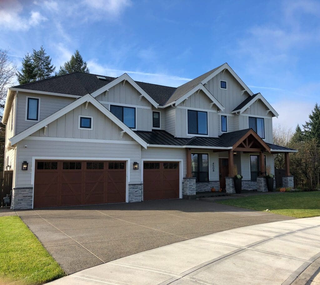 A mixture of Composite shingles and metal roofing on a beautiful custom home to illustrate architectural shingles vs composite shingles.
