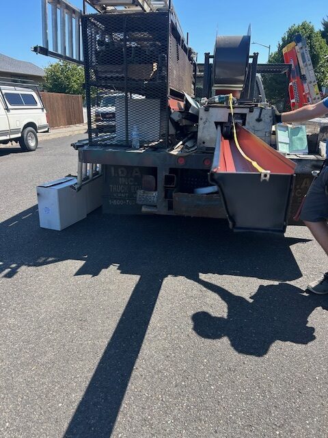 Truck with a machine that makes gutter to length on site to help illustrate gutter installation.