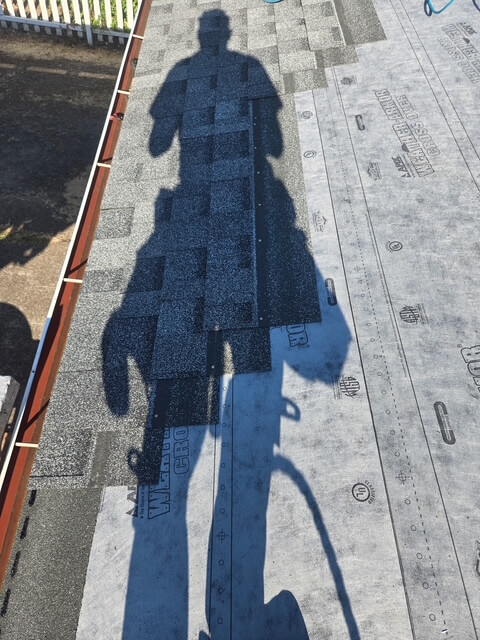 Shadow of a roofing contractor working on a roofing installation to help illustrate roofing company Hillsboro Or