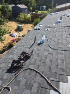 Top of a home during a re-roofing job with tools and new shingles to help illustrate apartment roofing services