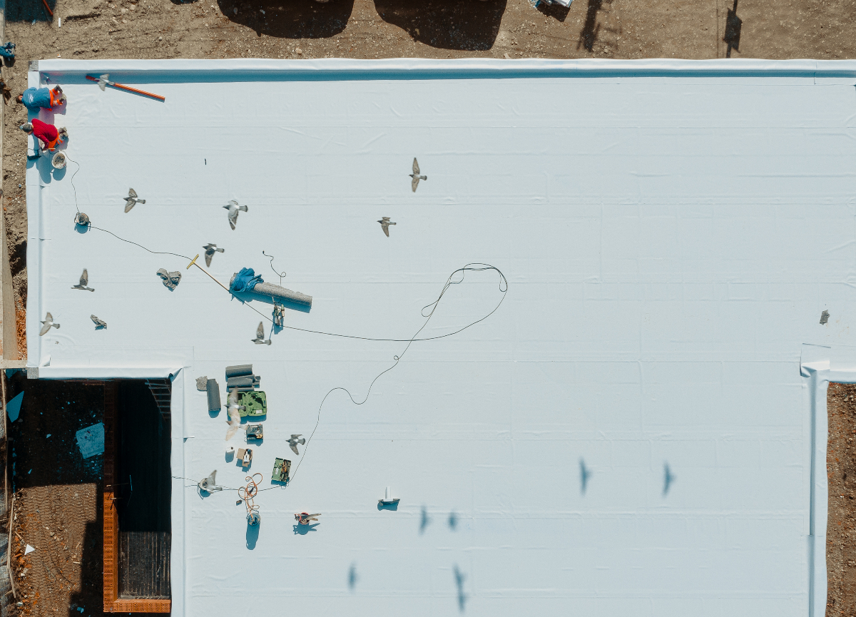 Aerial view of a flat roofing system, perhaps for a school, to help illustrate school roofing services