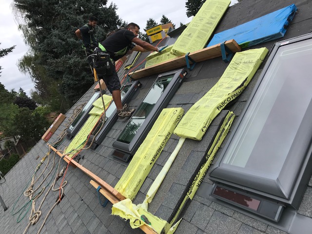4 solar powered opening skylights with solar powered blinds 2 – Warner Roofing on a roof installation to help illustrate installing a skylight.
