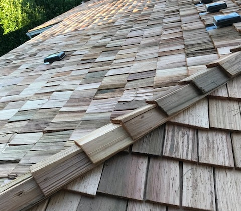 A cedar shake roof on a hip roof to illustrate residential roof types.