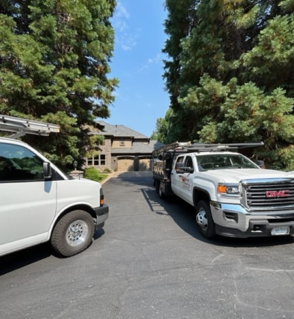 Warner Rpoofing vehicles in front of a nice home with a solid roof to help illustrate roof repair