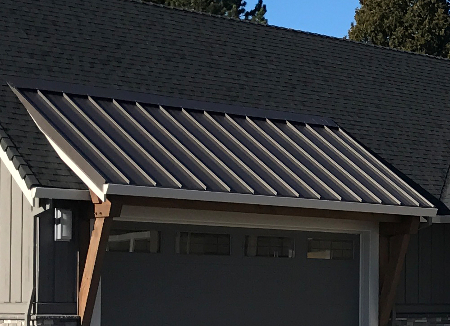 Metal roofing on an eave over a garage door to help illustrate types of metal roofing for residential homes